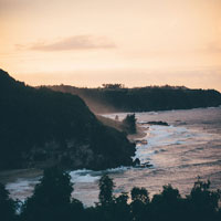 A picture of the ocean from a cliff at dusk.
